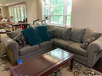 Front view of L-shaped sectional sofa with five seat cushions and decorative pillows