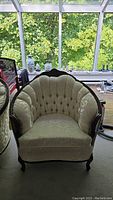 Front view showing scalloped button-tufted back and seat cushion