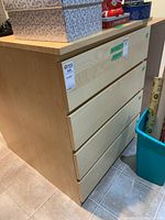 Front and side view of the dresser showing four drawers and light wood finish.