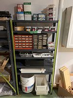 Full view of shelving unit filled with various boxes, bins, and containers primarily holding nails, screws, and hardware items.