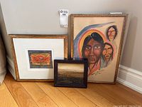 Three framed artworks arranged on floor showing size and style differences