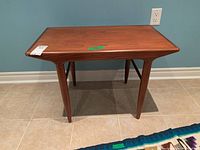 Front view of teak side table showing top surface and four tapered legs