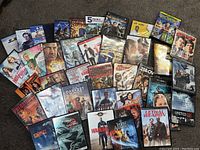 Top view showing the full collection of DVDs spread out on a floor with titles clearly visible in a mixed arrangement.