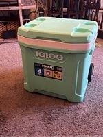 Front-side view showing the teal Igloo cooler with capacity and features label on the front.