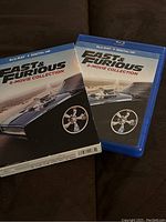 Front cover of the Blu-ray slipcase and case showing the Fast & Furious 8-Movie Collection logo and car wheel graphic.