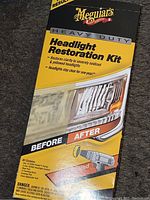 Front of the Meguiar's Heavy Duty Headlight Restoration Kit box showing product name, visual before and after images, and kit contents.