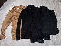 Four women's clothing items displayed laid flat, showing various fabrics and styles as described by seller.