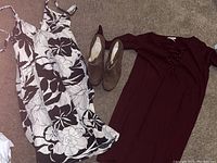 Lot with all three items displayed on carpet: black and white floral dress, maroon dress, and brown Michael Kors heels.