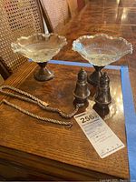 Showing two weighted sterling silver pedestal dishes with clear glass inserts, two weighted sterling silver salt and pepper shakers, and the 7-inch bracelet and 18-inch necklace.