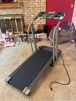 Side angle of the gray Pro-Form 380 treadmill showing running belt, handrails, and power cord.