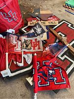 Photo of University of Houston themed flags, tote bag, wooden Texas state decor, and welcome signs arranged on the floor.