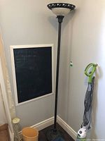Full view of the tall torchiere floor lamp in a corner, showing overall height and design.