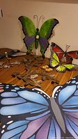 Overview of metal butterfly wall hangings in various colors and sizes along with butterfly floor mat.