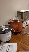 Photo showing Rival Retro rice cooker, Sunbeam Heritage crock pot, and Levoit humidifier on a table