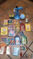 Overview photo showing all card games, toys including Top Trumps sets, Hex Bugs, fart toy and game, globe toy and handheld blue toy.