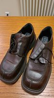 Pair of brown leather Stone Ridge shoes on a wooden surface.