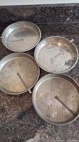Four vintage 8-inch round cake tins with easy release levers, showing texture and size