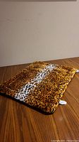 Small rectangular dog bed, plush leopard print fabric in brown, black, and white colors
