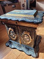 Front view of closed box showing floral panels on doors and top inlay
