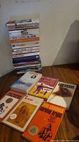 Stack of paperbacks and pocketbooks showing various titles and authors.