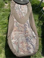 Full view of one camp lounger showing camouflage pattern fabric and brown trim.