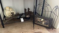 Wide shot showing all items including plaque, candle holder, wooden brackets, lidded box, framed art, and black metal decorative fence/rack.