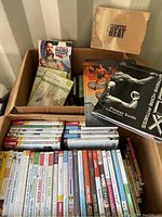 Box with various DVD cases visible, titles include Pilates, Yoga, Low Impact, The Firm series, 22 Minute Hard Corps, and a P90X booklet titled Fitness Guide.