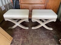 Pair of Ethan Allen ottomans placed side by side showing overall condition and design features including curved and carved wooden base with upholstered seats.