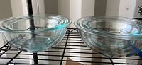 Two clear glass Pyrex bowls side by side showing thickness and rim design.