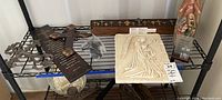 Wide view of shelf with religious items including crosses, plaques, and statue