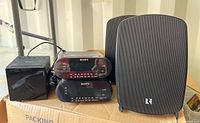 Photo showing two Sony Dream Machine clock radios model ICFC218, one Sony clock radio model ICFC1, and one Russound outdoor loudspeaker with mesh grille and logo.