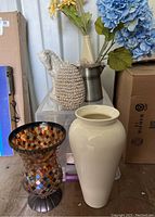 Full lot viewed from front showing all items: glass mosaic vase, large ceramic vase, horse statue, galvanized pitcher with faux flowers, small ceramic vase with faux flowers, orb covered in shells