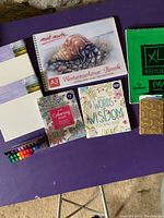 Overview of all items including watercolour book, coloring books, sketchpads, markers, and pencil crayons on a purple table.