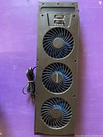 Full front view of the triple window fan showing three blue fans in a black frame with power cord.