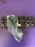 Four Siemens circuit breakers arranged on purple surface with auction tag and protective packaging