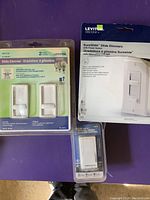 Front view of Leviton SureSlide Slide Dimmers in original packaging including a 2-pack and single units.