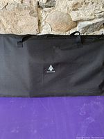 Black soft carrying case with Woods logo on front, zipped and used to store portable kitchen components.