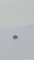 Loose oval cushion cut sapphire on white background