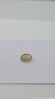 Image of one oval cut champagne citrine gemstone on a white background, showing its pale yellow champagne color and faceted surface.