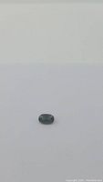 Loose oval cut green sapphire on white background