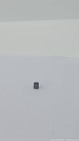 Photo showing front view of emerald cut deep forest green Tourmaline gemstone on white background, highlighting color and shape