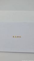 Four natural heart cut golden yellow sapphires shown in a row on a white background, highlighting their size, shape, and color