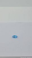 Top view of the marquis cut Swiss blue topaz gemstone showing its clear, polished facets and deep blue color against a white background.