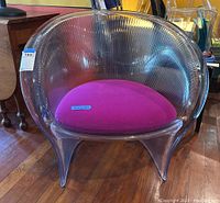 Front view of transparent ribbed polycarbonate chair with fuchsia cushion