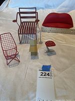 Five scale model chairs and sofa arranged on fabric backdrop