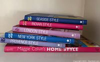 Stacked spines of six hardcover books from Taschen and Maggie Colvin showing titles including Seaside Style, Indian Style, London Style, New York Style, Provence Style, and Maggie Colvin's Home Style.