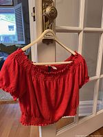 Red off-shoulder cropped blouse with elastic neckline and textured fabric shown front