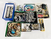 Top down view of all jewelry items laid out in multiple boxes showing variety of pieces included in the lot.