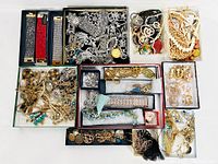Photo displaying a large assortment of estate jewelry including necklaces, bracelets, earrings, pins, and watches arranged in multiple boxes.