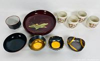 Top view of entire lot showing all lacquerware and ceramic pieces arranged in one line.
